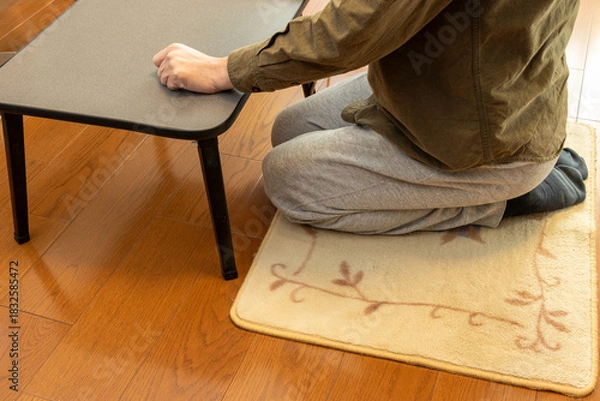 Fototapeta 床に敷いたカーペットの上に正座で座る男性
