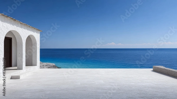 Fototapeta Beautiful coastal view from a serene terrace overlooking the deep blue sea with clear sky and classic white architecture