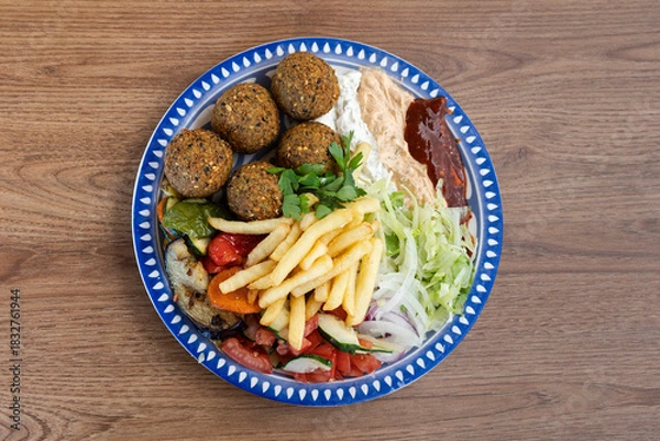 Obraz Falafel plate with hummus, fries, grilled vegetables, and salad