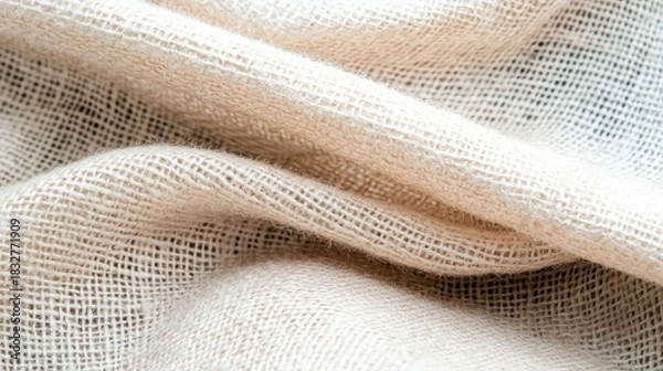 Fototapeta Close-up shot of a beige woven fabric with visible texture and detail, lit with soft lighting.