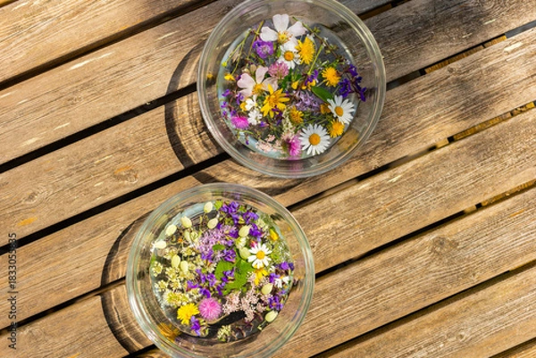 Fototapeta Alpine flowers and herbs macerating in water for the ritual of the Night of St. John (June 23-24), symbol of fortune and prosperity.