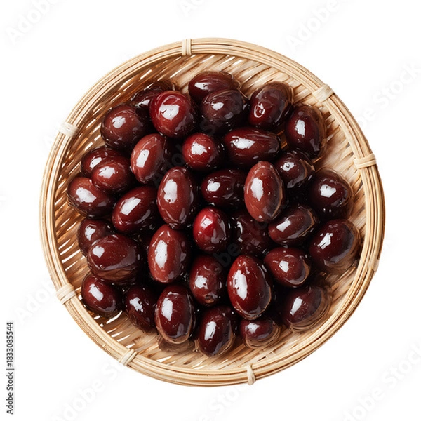 Fototapeta Delicious shiny dark cured olives in a rustic woven bamboo basket, top-down view