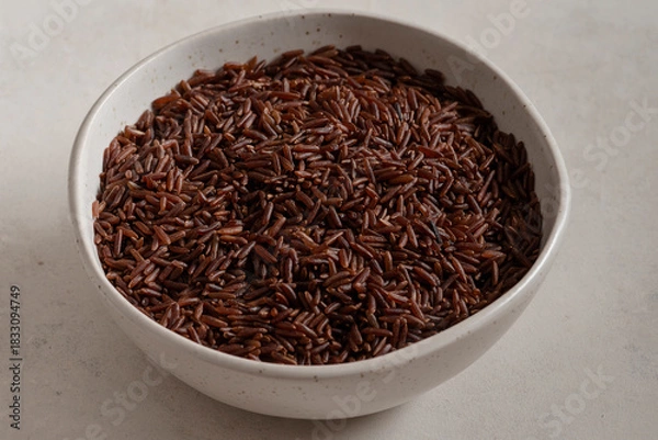 Obraz Bowl of long wholemeal red rice.