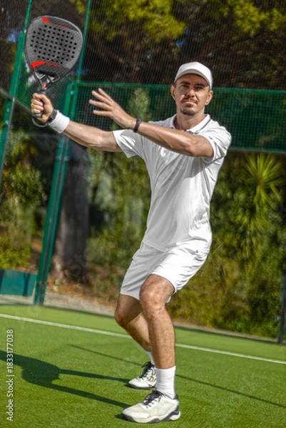 Obraz Padel player on the padel court with padel racket and ball in action. Open social tour template. Padel tennis player outdoors. Paddle tenis template for design ads with copy space.