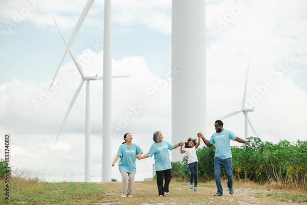 Obraz Volunteers are walking behind a windmill farm, volunteer charity people. charity community service event, ngo business and outreach, Group Diverse people meeting at park for donation