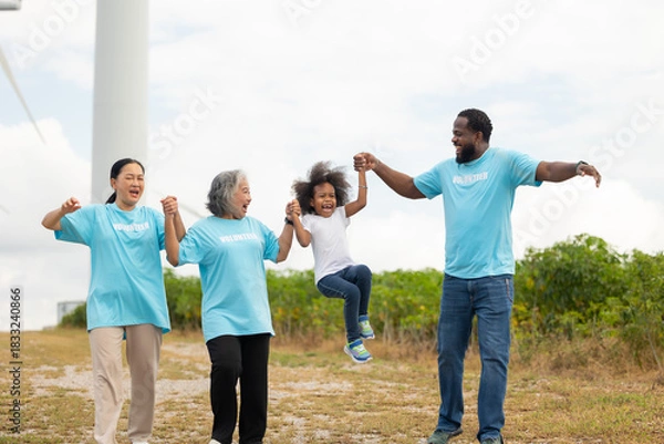 Obraz Volunteers are walking behind a windmill farm, volunteer charity people. charity community service event, ngo business and outreach, Group Diverse people meeting at park for donation