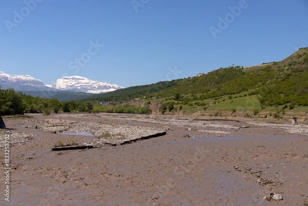 Fototapeta A muddy river in a canyon in the mountains.