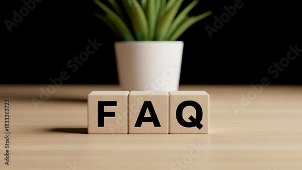 Fototapeta Faq spelled out in wooden blocks with a plant in the background on a light brown surface view from front