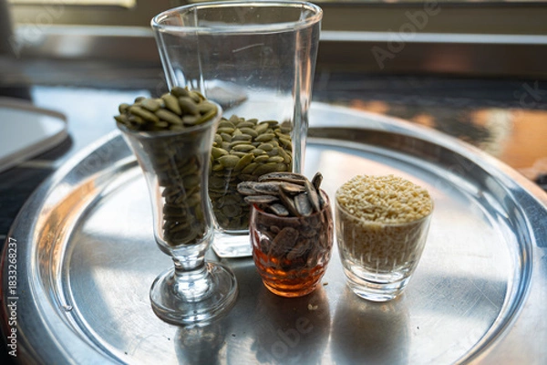 Fototapeta Still life with sunflower, sesame, and pumpkin seeds in glass cups