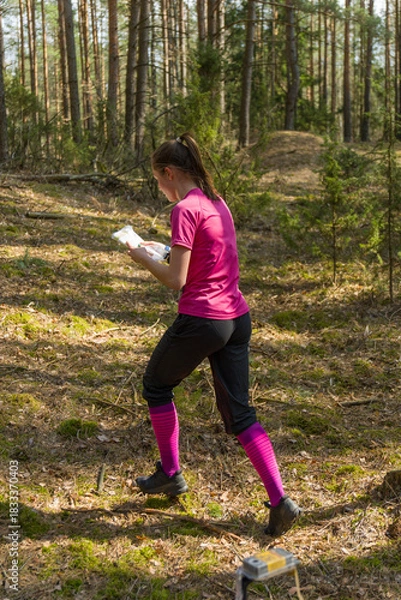 Obraz Young woman orienteer in pink shirt and black pants