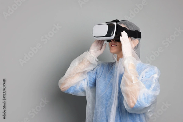 Obraz Modern technology. Doctor using virtual reality headset on grey background. Space for text