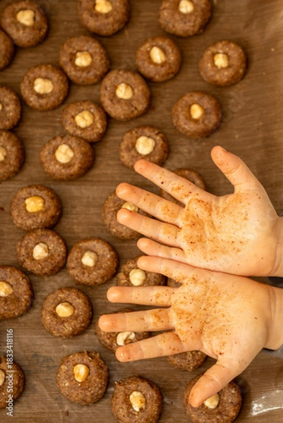 Fototapeta Close up of child's messy palms covered in dough and spices after baking. Fun and authentic Christmas lifestyle shot