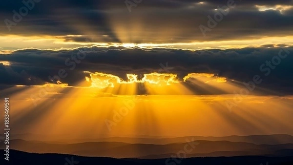 Obraz Sun rays piercing through clouds, creating a dramatic and ethereal atmosphere.