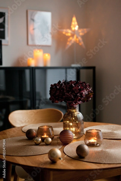 Obraz Cozy home atmosphere. Christmas lights and decoration on wooden table in nordic interior.
