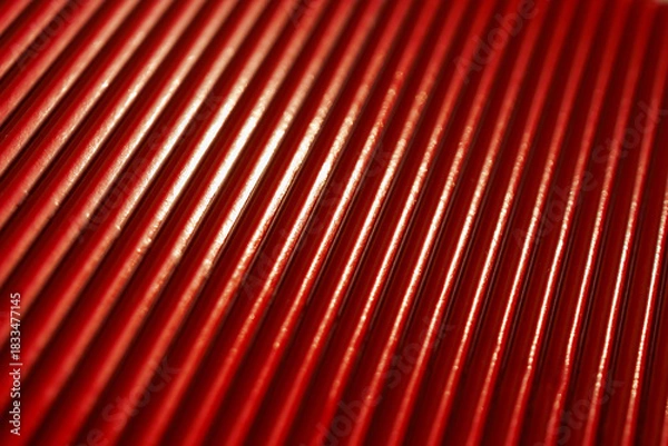 Fototapeta abstract red metallic texture with rhythmic reflective ridges and dynamic light highlights