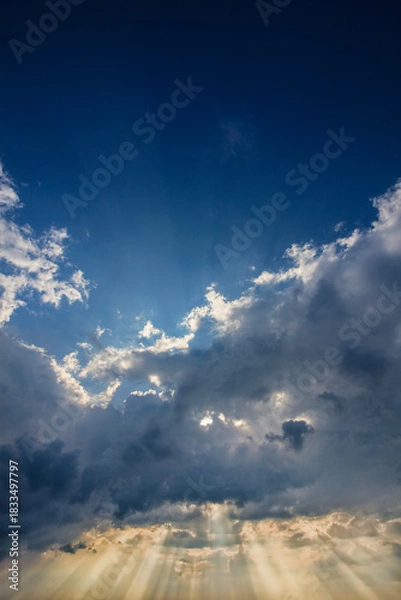 Fototapeta Dramatic sky with sun rays penetrating clouds
