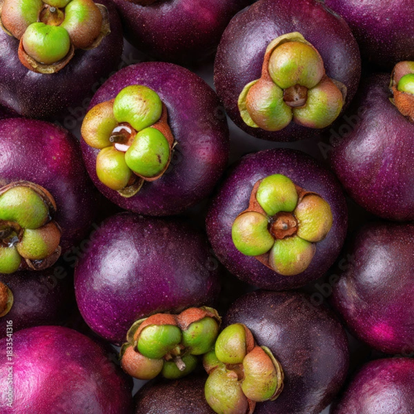 Obraz A stack of fresh mangosteens with deep purple rinds and green caps, arranged neatly. Perfect for tropical fruit markets, healthy food themes, and vibrant produce displays.
