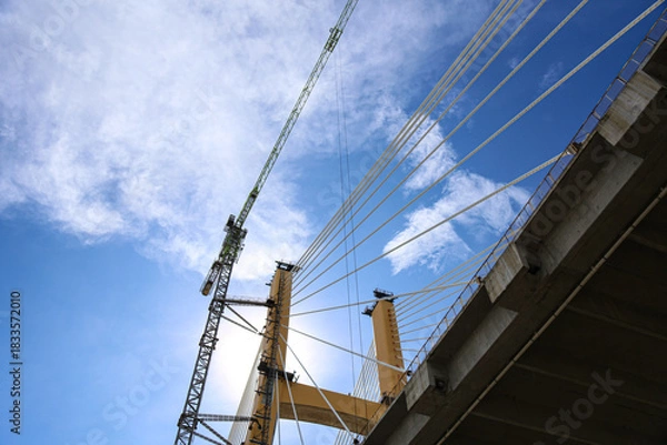 Obraz Cable-Stayed Bridge Construction with Tower Crane Under Blue Sky