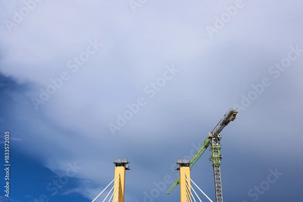 Obraz Cable-Stayed Bridge Construction with Tower Crane Under Blue Sky