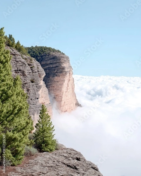 Fototapeta Scenic landscape featuring a cliff, clouds, trees, and blue sky. The image captures a natural environment with a bright, airy atmosphere.