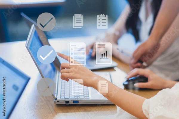 Fototapeta 会議でパソコンを操作しながら意見交換する女性たち