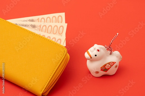 Obraz A yellow wallet and a Japanese ornament of the zodiac Horse. Money luck, financial situation, economy in the Year of the Horse, etc.　黄色財布と干支の午の置物。金運、お金事情、午年の経済など
