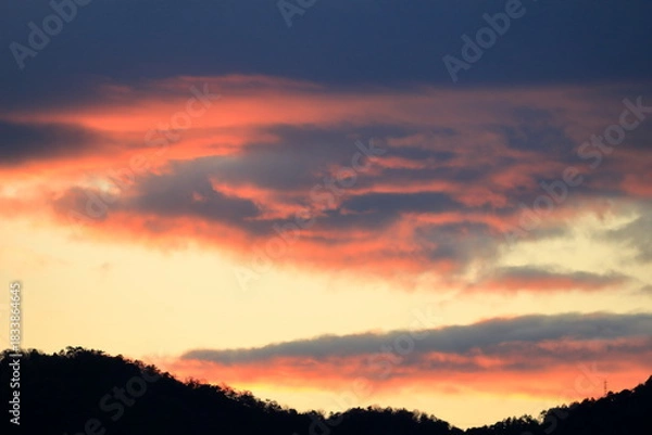 Obraz 夕日に染まった山向こうの雲
