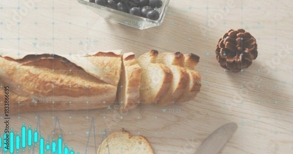 Fototapeta Showing sliced baguette lying on wooden table, with berry bowl, pinecone, knife, turquoise overlay