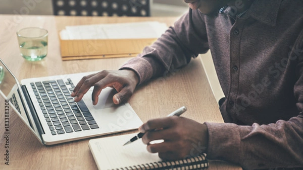 Fototapeta A businessman using computer in office