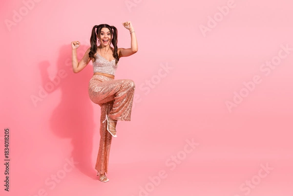 Obraz Young woman in pink sequined outfit dancing joyfully in a pink studio for fashion lifestyle and party advertisement