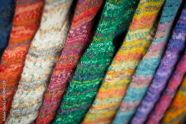 Obraz Close-up of colorful hand-knitted socks arranged in a row, showcasing their varied patterns and textures.