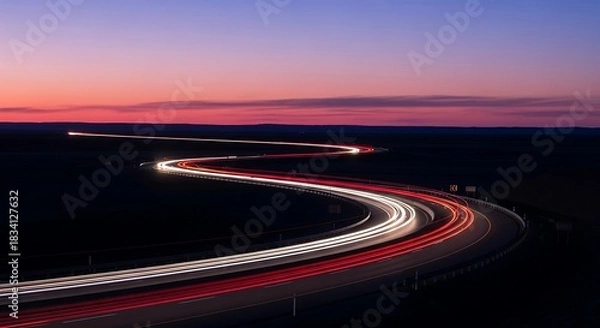 Fototapeta Long exposure light trails on a winding road at twilight.