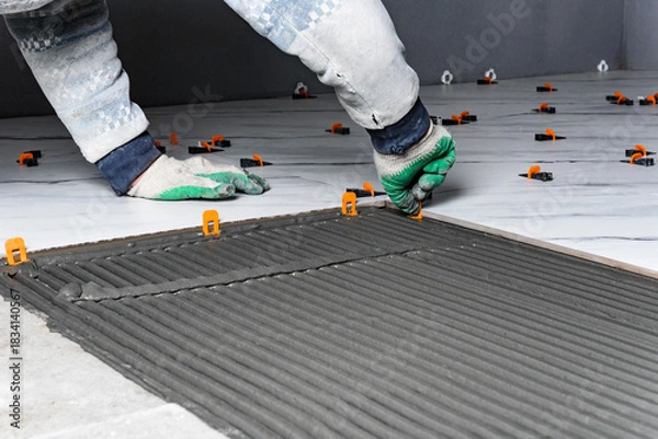 Fototapeta Installing the tiling system (clips) before laying tiles.