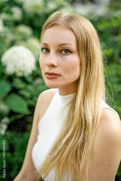 Obraz A blonde woman with green eyes in a garden