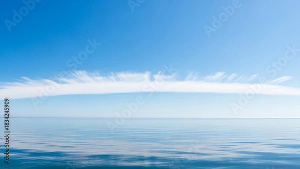 Fototapeta Calm blue ocean water horizon with clear sky and soft white cloudscape view