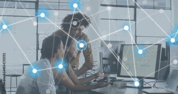 Fototapeta Working three coworkers in casual tops leaning in office, pointing at monitors and network overlay