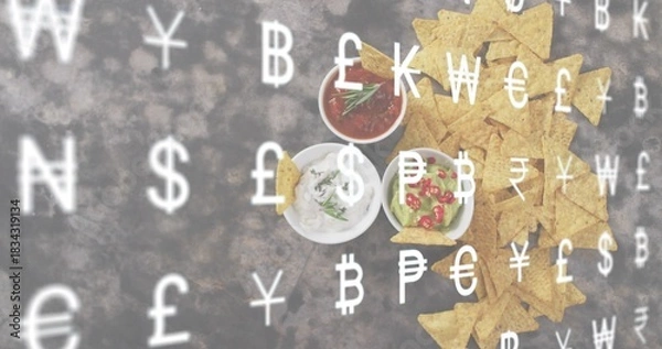 Fototapeta Displaying triangular tortilla chips and three bowls on dark tabletop, currency overlay, copy space