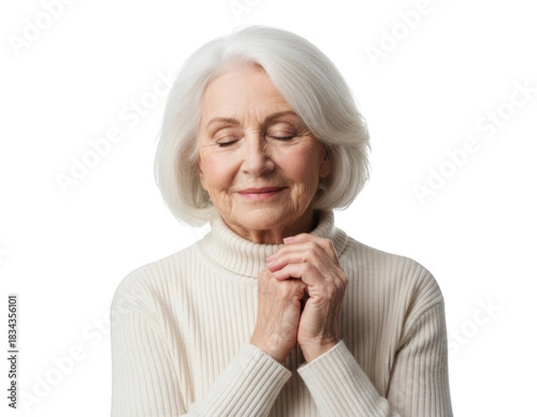 Obraz Serene senior woman with white hair and closed eyes, hands clasped in contemplation while wearing a cream turtleneck