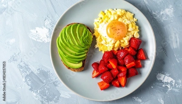 Fototapeta Start your day with a vibrant, wholesome breakfast of avocado toast, scrambled eggs, and fresh strawberries for energy and wellness