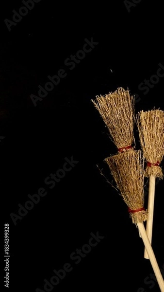 Obraz Mini witch brooms on black background, occult props, mystical composition, esoteric tools for magic and rituals
