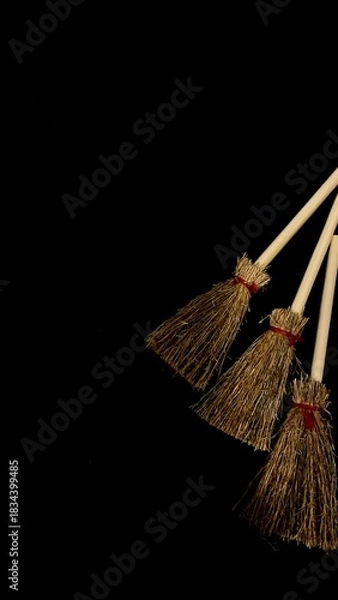 Obraz Mini witch brooms on black background, occult props, mystical composition, esoteric tools for magic and rituals