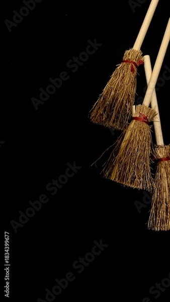 Obraz Mini witch brooms on black background, occult props, mystical composition, esoteric tools for magic and rituals