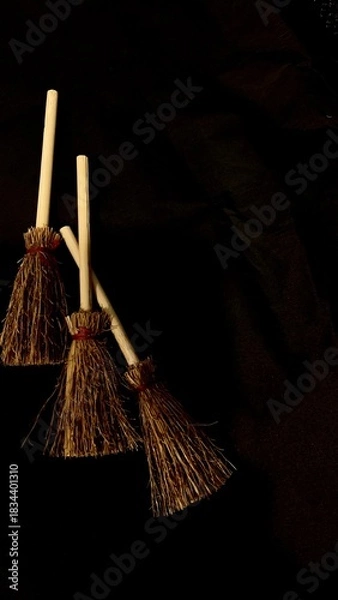 Obraz Mini witch brooms on black background, occult props, mystical composition, esoteric tools for magic and rituals