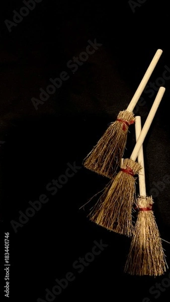 Obraz Mini witch brooms on black background, occult props, mystical composition, esoteric tools for magic and rituals