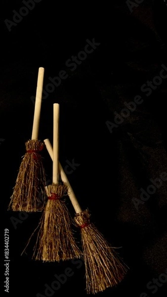 Obraz Mini witch brooms on black background, occult props, mystical composition, esoteric tools for magic and rituals