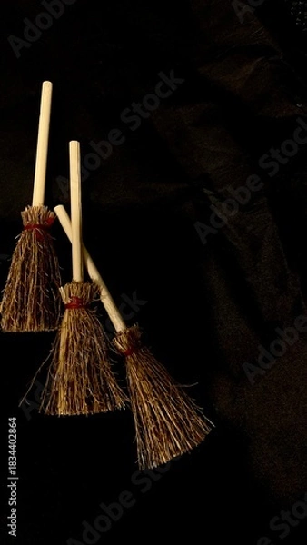 Obraz Mini witch brooms on black background, occult props, mystical composition, esoteric tools for magic and rituals