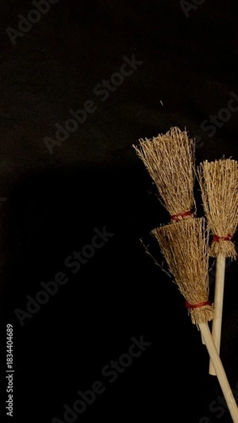 Obraz Mini witch brooms on black background, occult props, mystical composition, esoteric tools for magic and rituals
