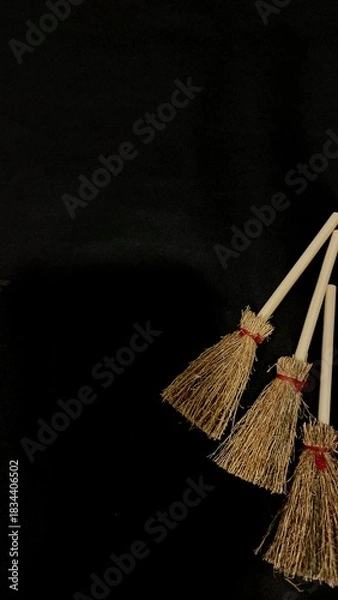 Obraz Mini witch brooms on black background, occult props, mystical composition, esoteric tools for magic and rituals