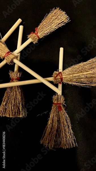 Obraz Mini witch brooms on black background, occult props, mystical composition, esoteric tools for magic and rituals