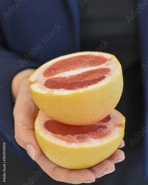 Obraz Fresh grapefruit halves in hands